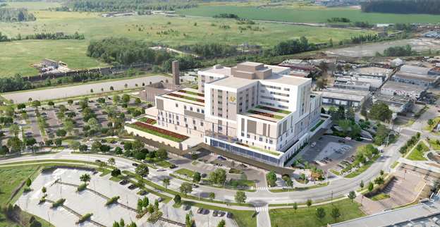 A digital rendering of a large, modern hospital building with multiple stories and green rooftop terraces, surrounded by parking lots, roads, and landscaped areas. The hospital is set against a backdrop of green fields and trees.